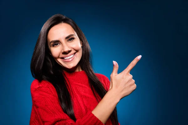 Foto von niedlichen süßen jungen Dame tragen gestrickte Pullover lächelnd Zeigefinger leeren Raum isoliert Gradienten blaue Farbe Hintergrund — Stockfoto