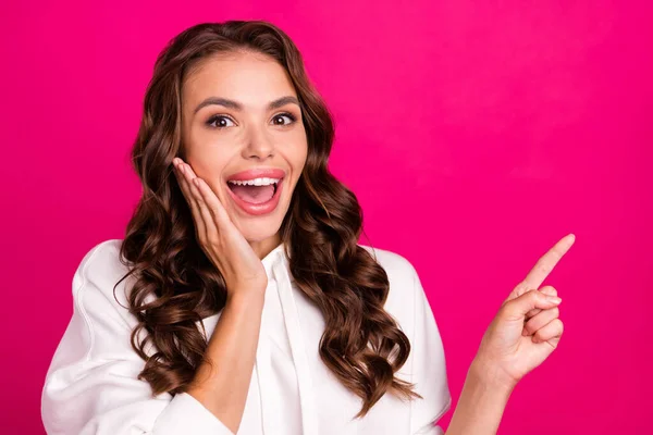 Photo de jeune fille heureux sourire positif étonné pointe doigt espace vide publicité choisir vente isolé sur fond de couleur rose — Photo