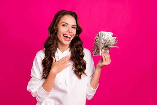 Photo de jeune fille heureux sourire positif gagner loterie jackpot inattendu millionnaire argent dollars isolés sur fond de couleur rose — Photo