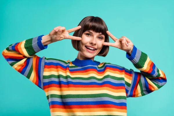 Fényképezés portré mosolygós lány pulóver mutatja v-jel gesztus elszigetelt élénk kék szín háttér — Stock Fotó