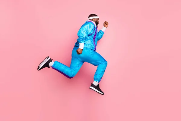 Full size profil boczne zdjęcie młodego czarnego sportowca go walk uruchomić szybki skok pośpiech izolowane na różowy kolor tła — Zdjęcie stockowe