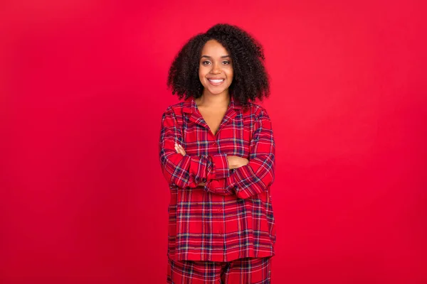 Foto de confiante jovem afro-americana segurar as mãos cruzado sorriso pijama partido isolado no fundo de cor vermelha — Fotografia de Stock