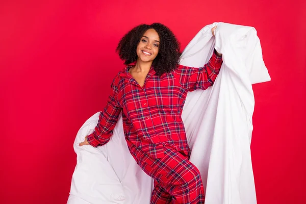 Modayı takip eden mutlu Afro-Amerikan kadının fotoğrafı. Sıcak battaniyeli gece elbisesi kırmızı arka planda izole edilmiş. — Stok fotoğraf