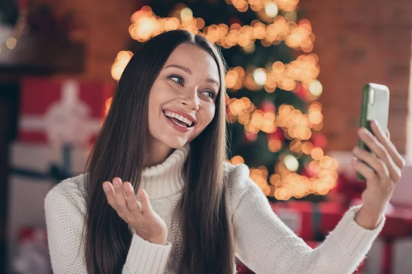 Foto de linda mujer joven divertida vestida de punto suéter hablando dispositivo moderno sonriendo interior habitación casa —  Fotos de Stock