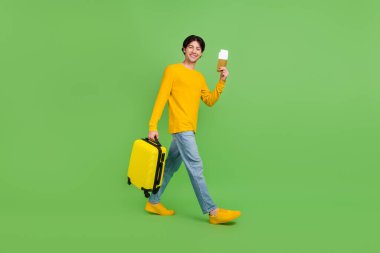 Full length body size photo man with luggage showing plane tickets isolated pastel pink color background clipart