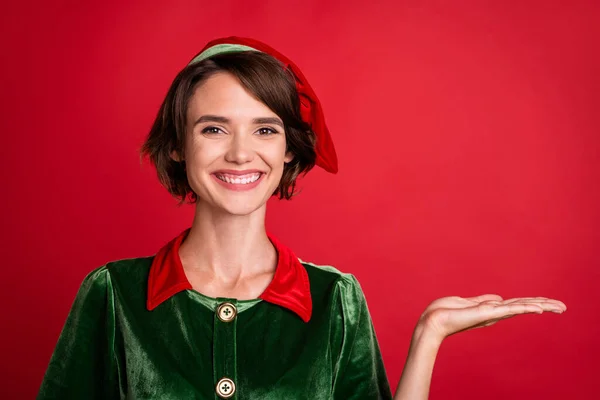 Photo du promoteur dame paume démontrer vide espace vente nouveauté porter elfe costume chapeau isolé couleur rouge fond — Photo
