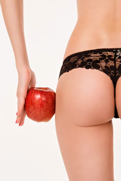 Weibliche Formen und roter Apfel. Rückansicht eines jungen Mädchens mit schönem Po. Frauenkörper isoliert. Konzept der Ernährung, gesunde Ernährung, Cellulitis. Körperpflege und Maß an den Oberschenkeln. — Stockfoto