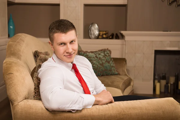 Homem bonito bem sucedido sentado no sofá depois do trabalho — Fotografia de Stock