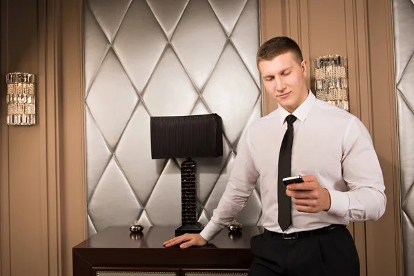 Successful businessman holding a smartphone. handsome man is typing a message on phone — Stock Photo, Image