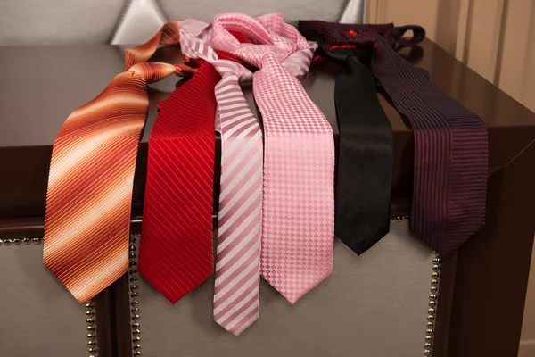 Morning choice which tie to wear? Six neckties in different colors lying on the dresser — Stock Photo, Image