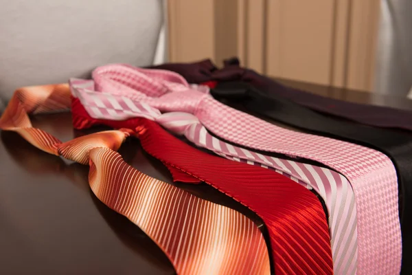 Welche Krawatte sollte man am Morgen anziehen? sechs Krawatten in verschiedenen Farben liegen auf der Kommode — Stockfoto