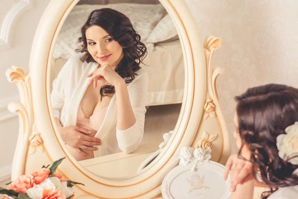 Pregnant looking in the mirror in the bedroom — Stock Photo, Image