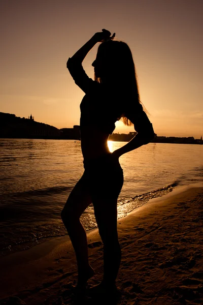 Silhouette eines schlanken Mädchens bei Sonnenuntergang — Stockfoto