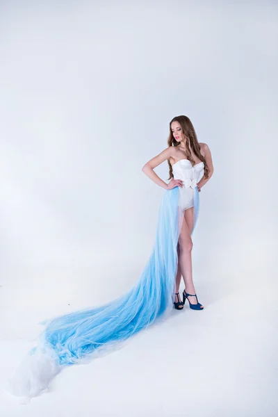 Tüy ile uzun mavi elbiseli güzel kız — Stok fotoğraf