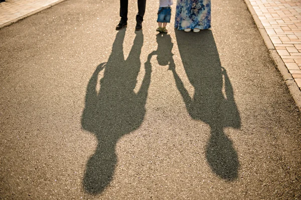 Família a andar com o bebé. imagem das sombras da família — Fotografia de Stock
