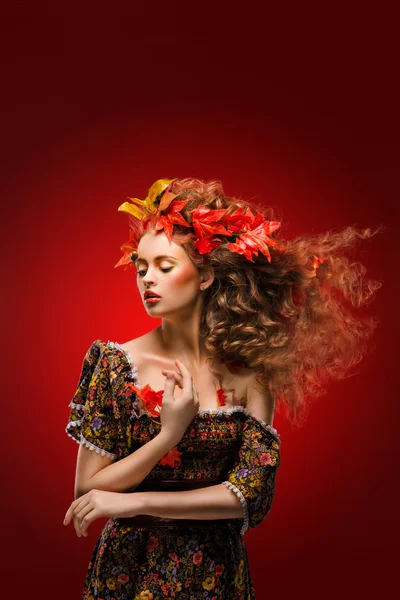Осенняя девушка на красном фоне — стоковое фото