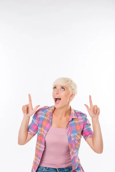 Happy young girl in casual shirt pointing up — Stock Photo, Image