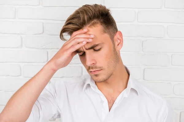 Kopfschmerzen. Depressiver Mann berührt seinen Kopf mit der Hand — Stockfoto
