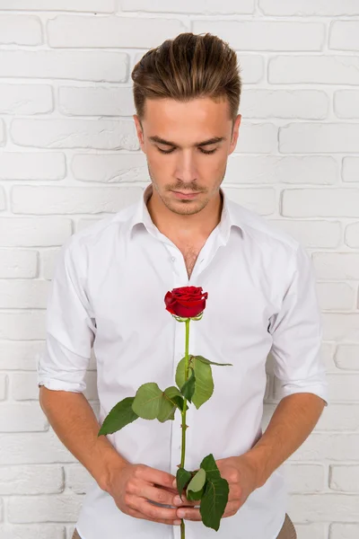 Hombre romántico sosteniendo una rosa — Foto de Stock