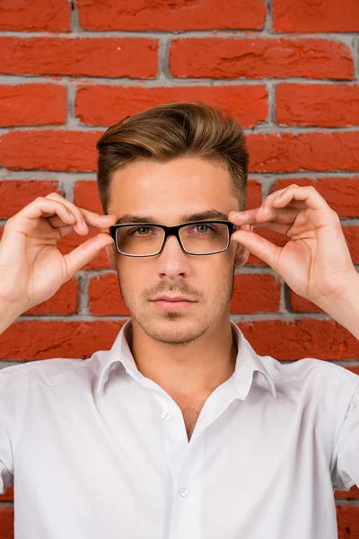Bonito homem ajusta seus óculos — Fotografia de Stock