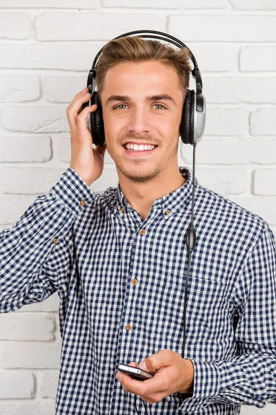 Стильный мужчина слушает музыку в наушниках — стоковое фото