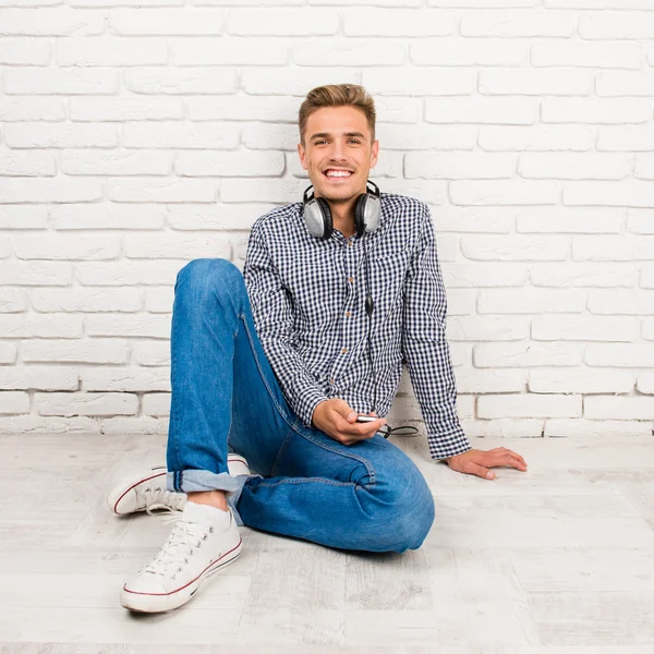 Hombre con auriculares sentado en el suelo —  Fotos de Stock