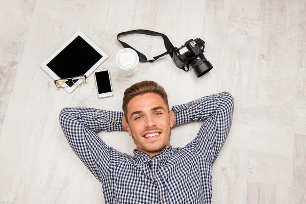 Vista superior del hombre acostado en el suelo con cámara, tableta, café , — Foto de Stock