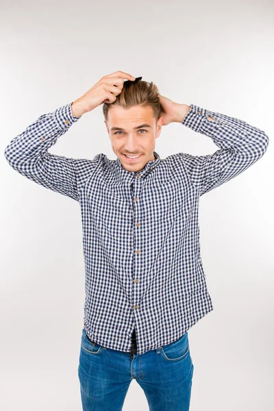 Handsome young man brushing his hair — Stock Photo, Image