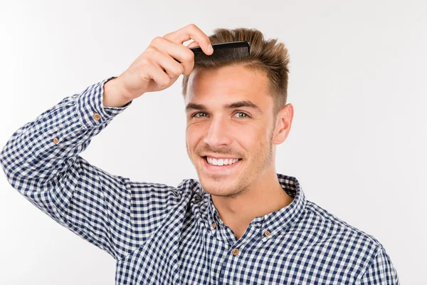 Красивий молодий чоловік чистить волосся — стокове фото