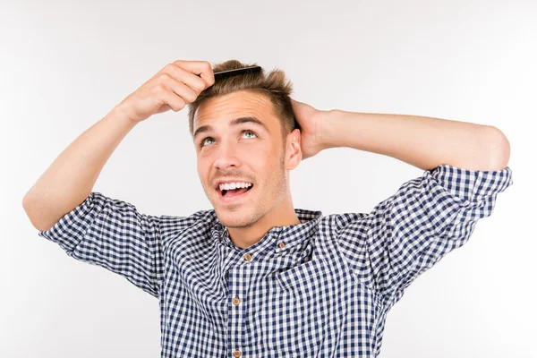 Handsome young man brushing his hair — Stock Photo, Image