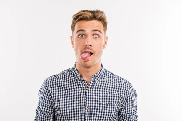 Cheerful young man sticking his tongue out — Stock Photo, Image