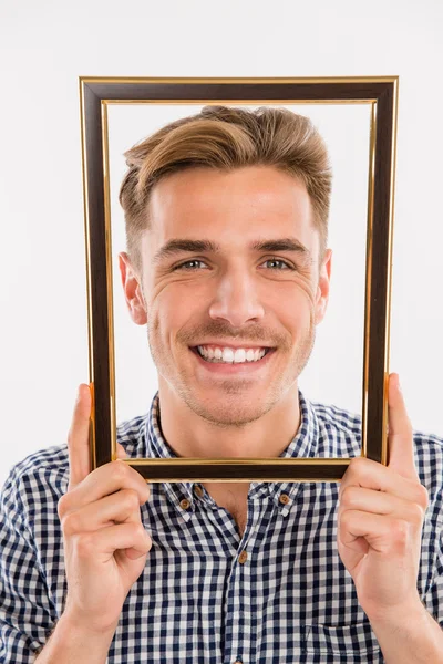 Man holding a picture frame in front of his face — Stock Photo, Image