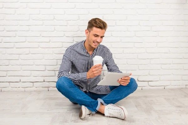 Man zittend op de vloer met digitale Tablet PC- en koffie — Stockfoto