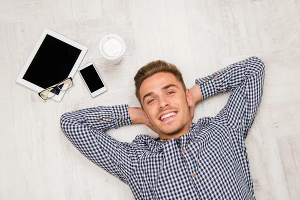 Vista superior del hombre acostado en el suelo con tableta, café y teléfono — Foto de Stock