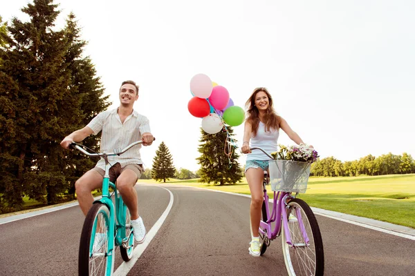 Happy couple together to ride a bicycle — Stock Photo, Image