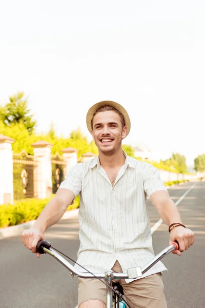 Jovem feliz de chapéu andando de bicicleta Imagem De Stock