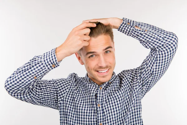 Schöner junger Mann streicht sich die Haare — Stockfoto