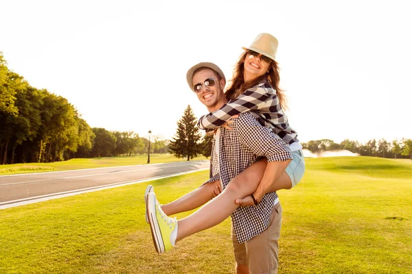 Feliz joven hombre piggybacking su novia . —  Fotos de Stock