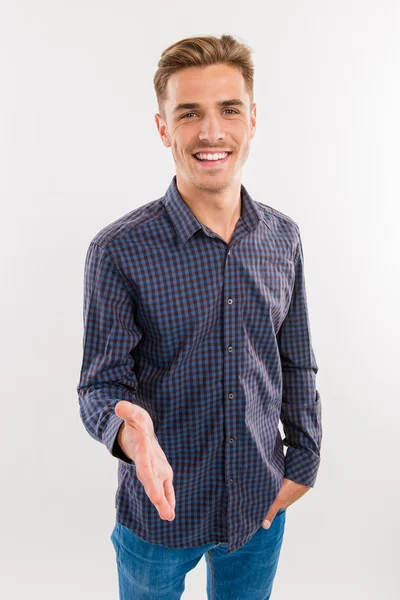 Handsome young man gives a hand for a handshake — Stock Photo, Image
