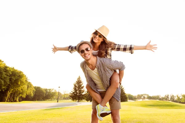 Feliz joven hombre piggybacking su novia . — Foto de Stock