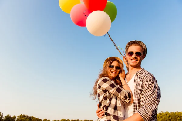 Casal apaixonado andando com balões — Fotografia de Stock