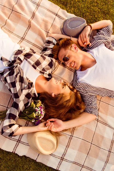 Visão superior de um casal apaixonado deitado em um piquenique xadrez — Fotografia de Stock