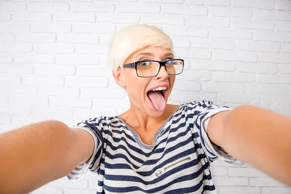 Mädchen macht Selfie und zeigt ihre Zunge — Stockfoto