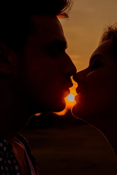 Silhueta de casal beijando ao pôr do sol — Fotografia de Stock