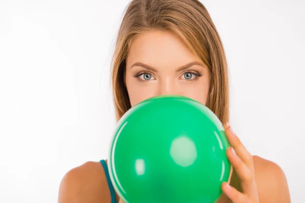 Ελκυστικό κορίτσι με τα πράσινα μάτια, φουσκώνοντας ένα μπαλόνι — Φωτογραφία Αρχείου