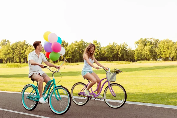 Счастливая пара влюблённых катается на велосипедах, развлекаясь — стоковое фото