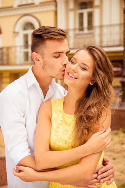 Jovem bonito beijando a bochecha de sua namorada — Fotografia de Stock