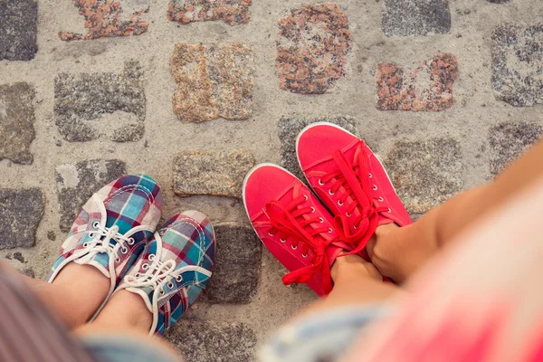 Top view of a two pairs of sneakers shoes walking on paving ston — Stock Photo, Image