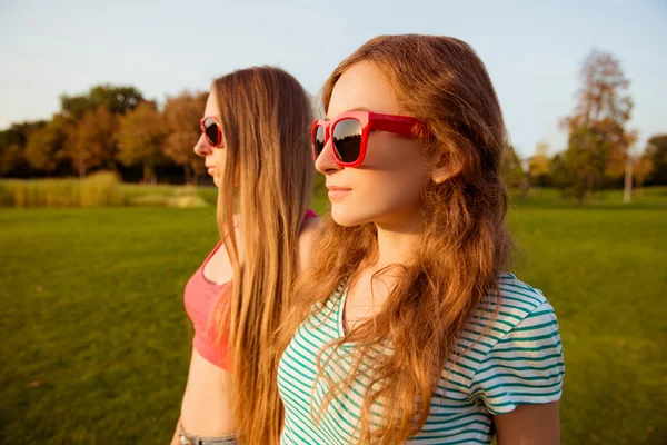 Twee mooie jonge meisjes die kijken naar de prachtige zonsondergang — Stockfoto