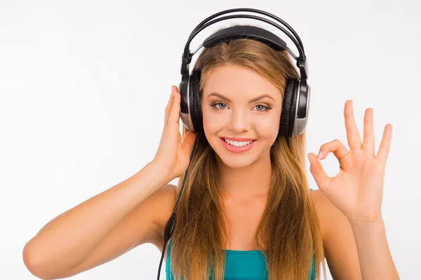 Menina sexy ouvir música em fones de ouvido gesticulando OK — Fotografia de Stock